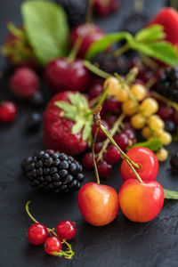 Mixed berries on a dark background with selected focus. strawberries, raspberries, cherries, 