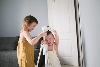 Children brother 1 year old and sister 4 years old play together with tripod for photos in real 