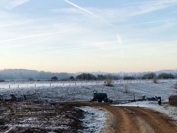 Dirt road against sky during winter