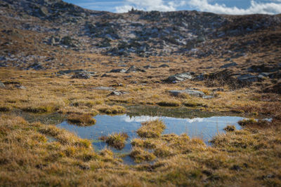 Closeup of mountain pond  with profile of small cemetery from first world war, south tyrol, italy