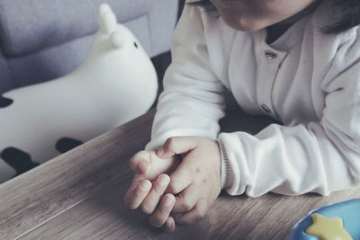 Midsection of baby girl at table