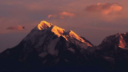 Scenic view of snowcapped mountains against sky during sunset