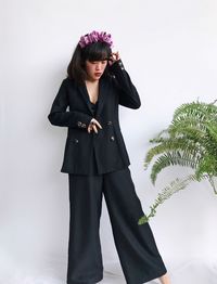 Young woman standing against plants