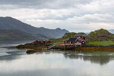 Red house with wooden pier on the shore of the lake