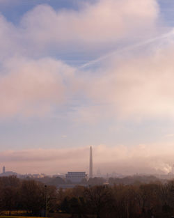 Smoke stacks against sky during sunset