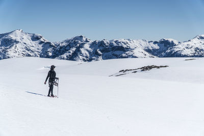 Person on snowcapped mountain against sky