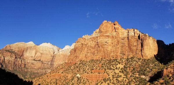 Rock formations on mountain against blue sky