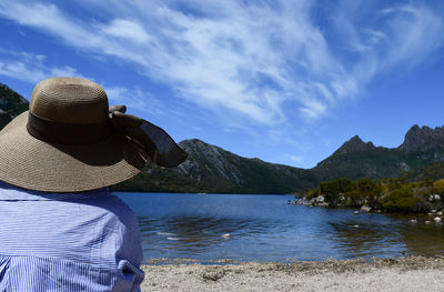 Rear view of man looking at mountains against sky