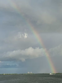 Scenic view of rainbow over sea against sky