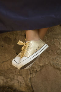 Low section of woman wearing canvas shoes outdoors