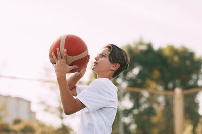 Side view of boy playing with ball