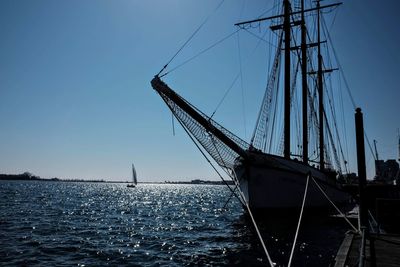 Sailboat sailing in sea against clear blue sky