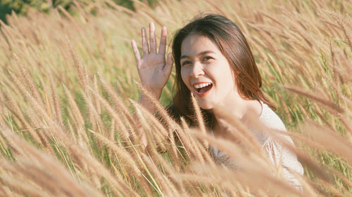 Portrait of smiling young woman lying on field