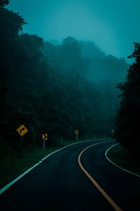 Road amidst trees against sky