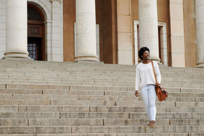 Full length of woman standing on staircase