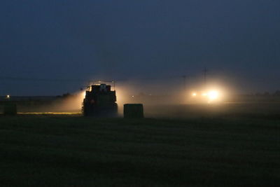 Scenic view of illuminated field against sky at night