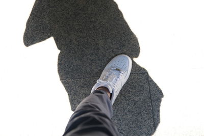 Low section of person standing against white background