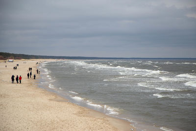 People at beach against sky