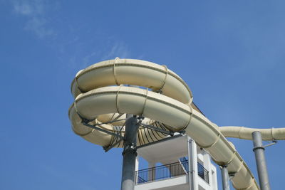 Low angle view of ferris wheel against clear blue sky