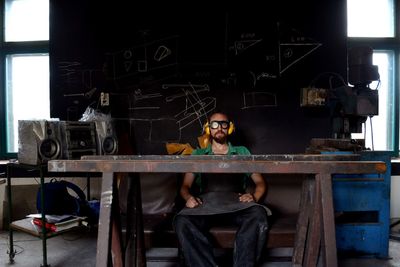 Portrait of young man sitting on table