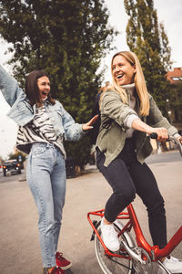 Portrait of smiling friends using mobile phone