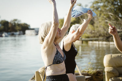 Carefree senior female friends dancing during vacation on houseboat