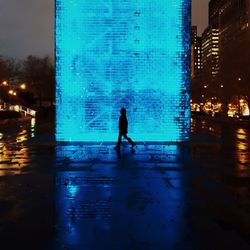 Woman standing in illuminated city at night