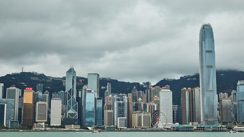 Modern buildings in city against cloudy sky