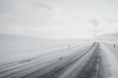 Scenic view of road against sky during winter