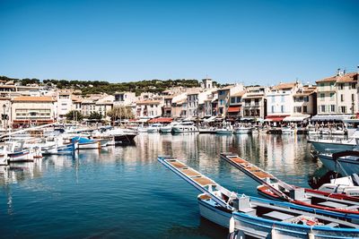 Sailboats moored at harbor against clear blue sky