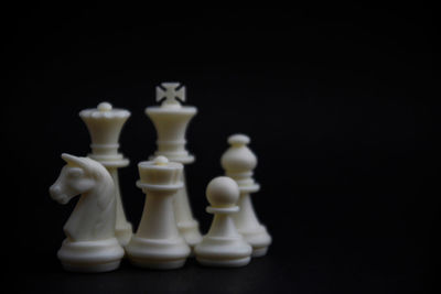 Close-up of chess pieces against black background