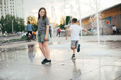 Full length of children on wet umbrella during rainy season