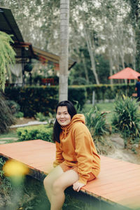 Portrait of young woman sitting on bench