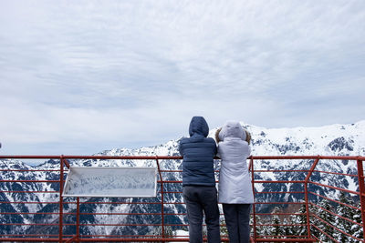 Rear view of people standing in winter