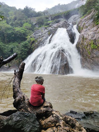 Rear view of woman looking at waterfall