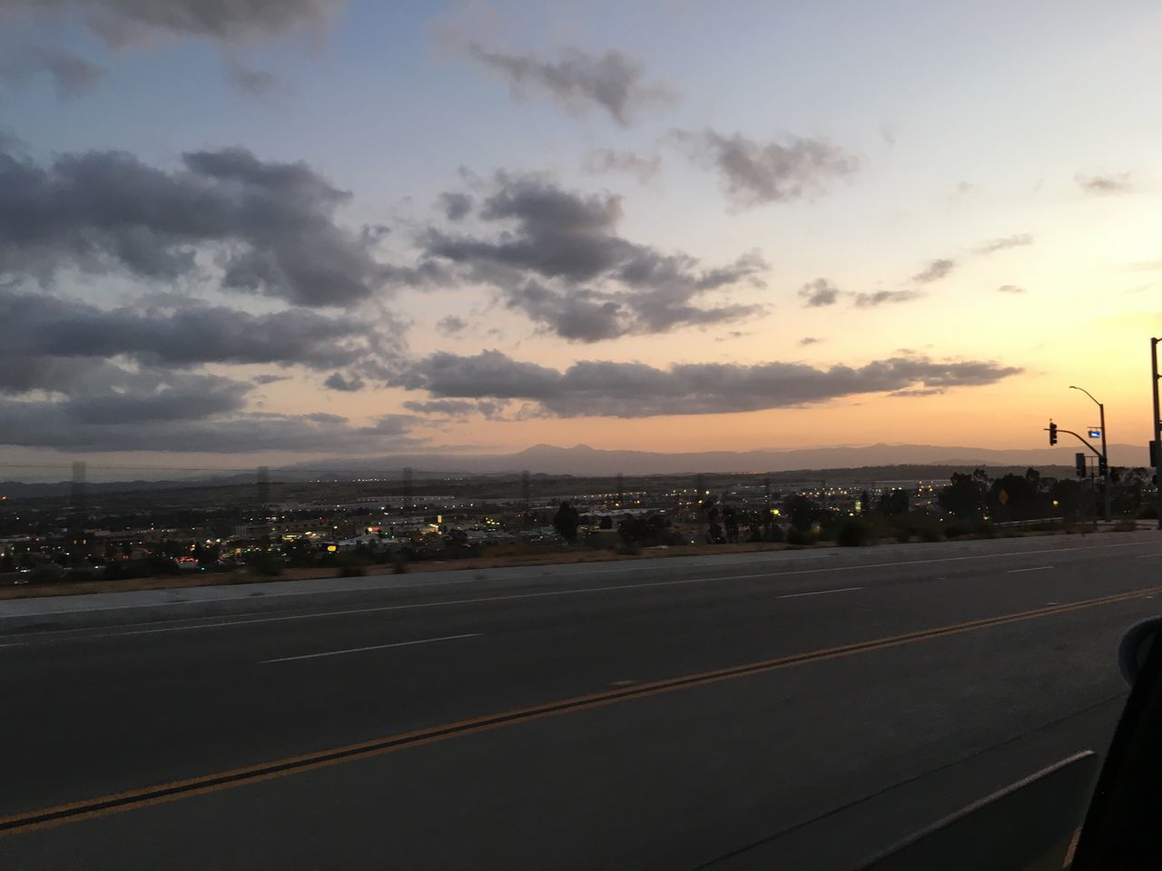 transportation, sky, road, road marking, sunset, cloud - sky, the way forward, street, dusk, scenics, landscape, cloud, empty, illuminated, outdoors, mode of transport, city, street light, highway, cloudy