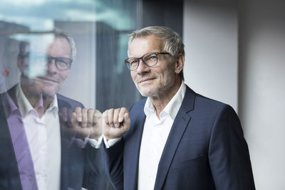 Confident businessman looking out of window