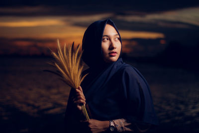 Portrait of woman standing against sky during sunset