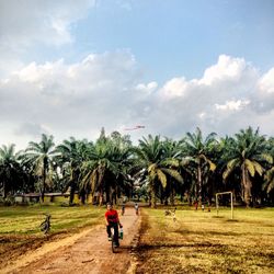 Man riding bicycle on dirt road