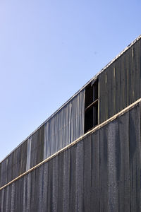 Low angle view of factory against clear blue sky