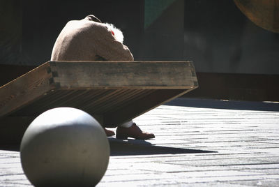 Close-up of man sitting on bench