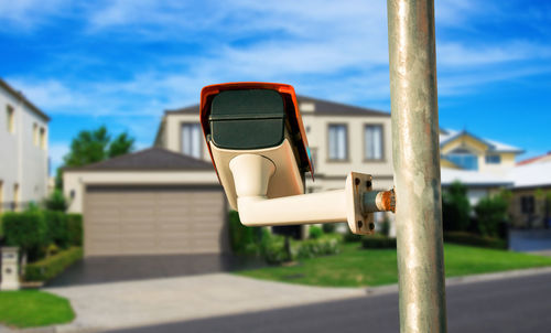 Empty chair outside house against sky on sunny day