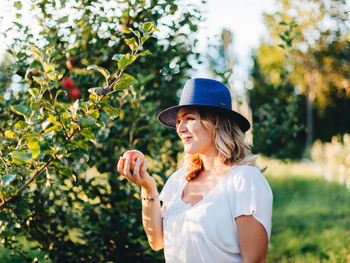 Young woman smiling against trees