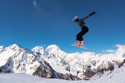 Low angle view of man skiing on snowcapped mountain against sky