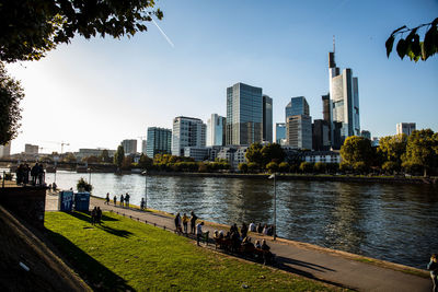 River by buildings in city against sky