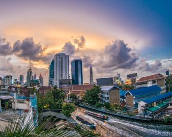 Aerial view of buildings in city against sky during sunset