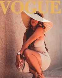 Young woman looking away while sitting on wall