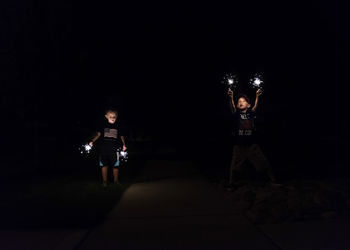 Boys playing with sparklers at night