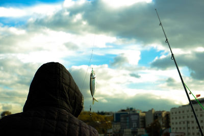 Rear view of woman standing against sky