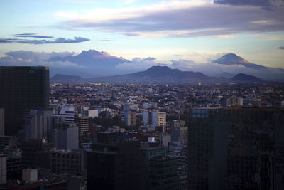 Aerial view of buildings in city against sky